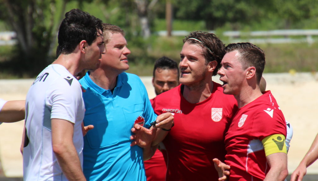 York9 FC's Joe Di Chiara (L) and Cavalry FC's Mason Trafford (C), Nik Ledgerwood (R) in action. (Photo: Nora Stankovic/CPL).