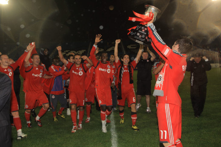 Former Toronto FC captain and current York9 FC head coach Jimmy Brennan lifts the Voyageurs Cup. (Photo: Canada Soccer).