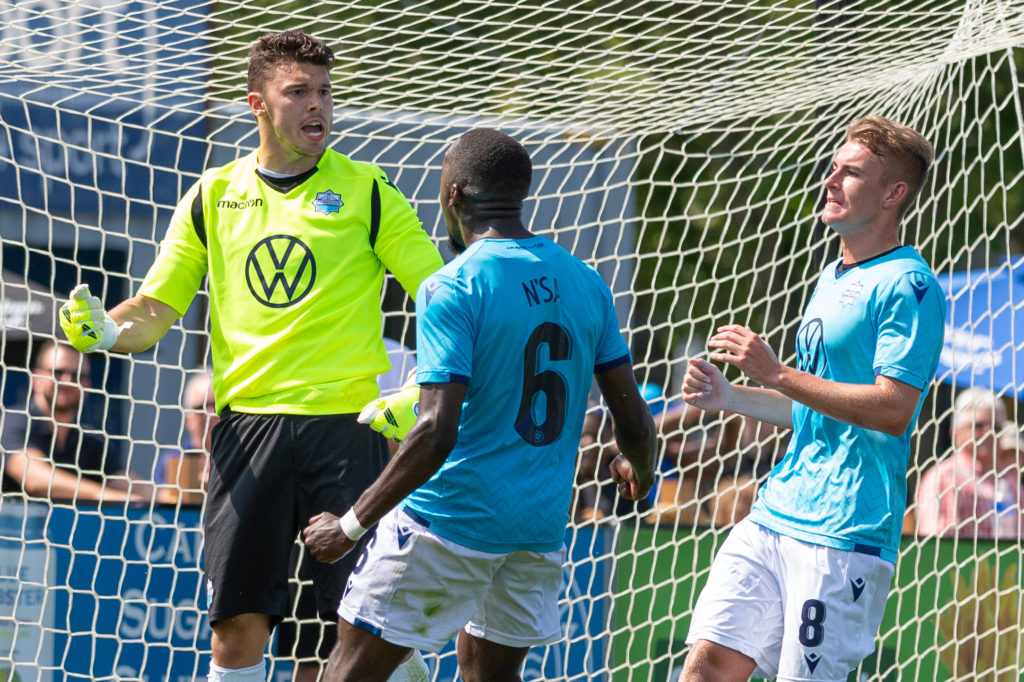 HFX Wanderers FC goalkeeper Christian Oxner celebrates with teammates after making a penalty kick save. (Trevor MacMillan/CPL).