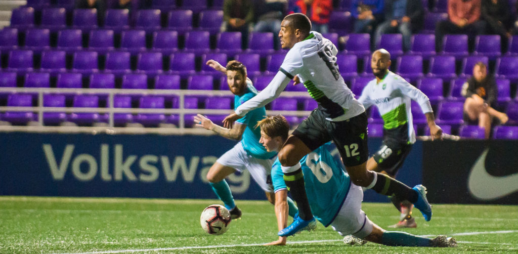 York9's Simon Adjei pushes past Pacific defender Lukas MacNaughton before scoring at Westhills Stadium. (Photo: Pacific FC).