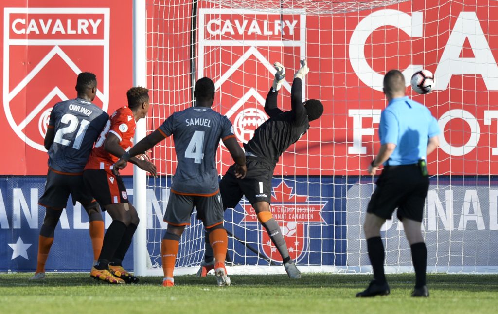 Dominique Malonga of Cavalry FC heads a goal past goalkeeper Triston Henry of Forge FC. (Mike Sturk/CPL).