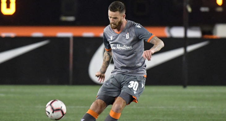 Oct 16, 2019; Hamilton, Ontario, CAN; Forge FC defender David Edgar (30) hits a pass against Cavalry FC in the first half of a Canadian Premier League soccer match at Tim Hortons Field. Mandatory Credit: Dan Hamilton-USA TODAY Sports for CPL