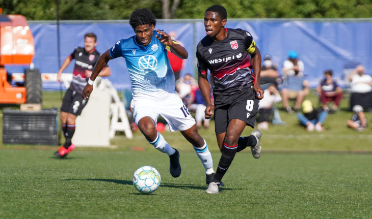 Andre Rampersad of HFX Wanderers dribbles past Elijah Adekugbe of Cavalry. (CPL/Chant Photography)