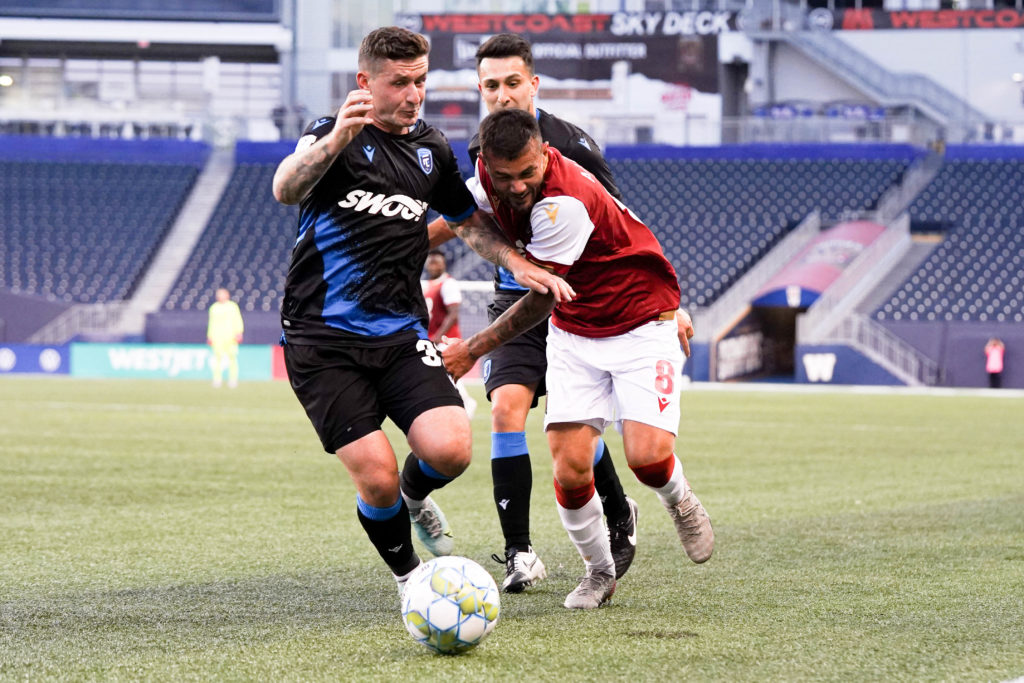 FC Edmonton's Fraser Aird fights with Keven Aleman of Valour FC for the ball. (Robert Reyes Ong / Valour FC)