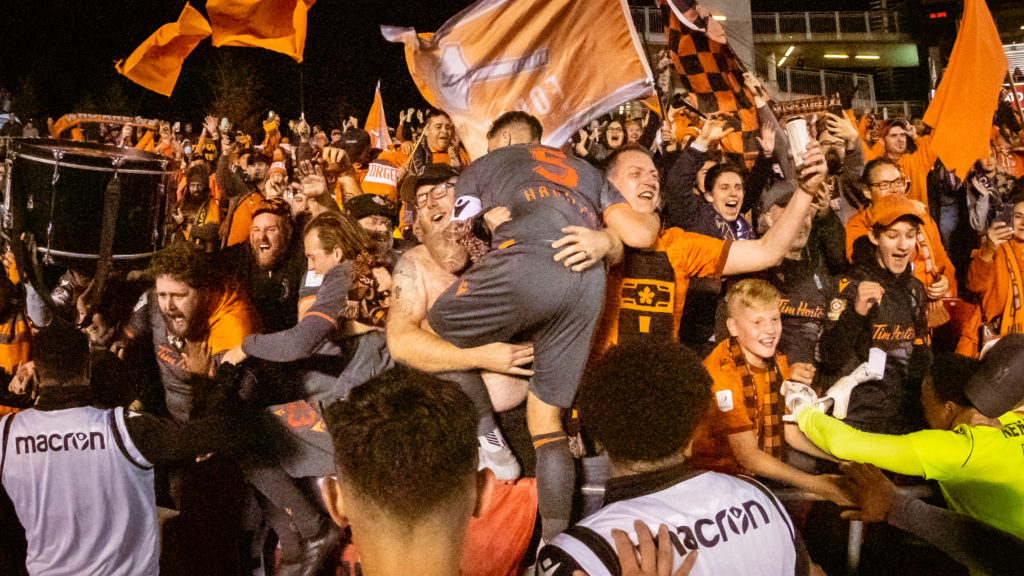 Daniel Krutzen of Forge FC leaps into the stands at TD Place to celebrate with Forge fans (Photo: David Chant)